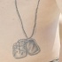 el tatuaje conmemorativo con una placa de identificacion hecho en color negro en el costado