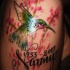 el tatuaje conmemorativo con un colibri hecho en el hombro en varios colores