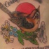 el tatuaje conmemorativo de un gorrion detallado con unas flores y el sol en elfondo, el nombre y fechas de la vida