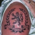 Tatuaje en brazo escudo memorial con leon