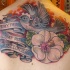 El tatuaje hermoso conmemorativo con un pájaro una flor y un frase hecho en color en la espalda