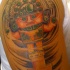 el tatuaje de un idolo azteca hecho en el brazo en varios colores