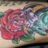 el tatuaje de catarina mexicana con una rosa grande hecho en varios colores