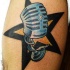 Tatuaje de micrófono con estrella al fondo