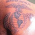 el tatuaje del simbolo militar de USMC en la espalda