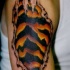 el tatuaje de una rotura de piel con la piel de tigre adentro hecho en el hombro
