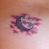 Tatuaje pequeño con luna creciente entre las nubes