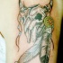el tatuaje de la calavera de una vaca con plumas en sus cuernos hecho en el hombro