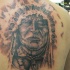el tatuaje  grande del jefe indio con corona de plumas hecho en la espalda