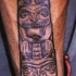 el tatuaje estilo indigeno con un totem de los animales hecho en el brazo
