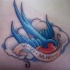 Tatuaje clásico con golondrina entre las nubes con inscripción