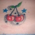 Tatuaje en color con las guindas rojas y las estrellas azules