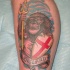 el tatuaje patriota de un leon humanizado con el escudo de inglaterra hecho en la pierna