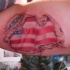 Bandiera americana sotto pelle stracciata tatuaggio sul braccio