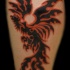 el tatuaje de la ave fenix en color negro con naranja en la pierna