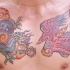 el tatuaje grande colorado de un dragon de estilo oriental y una ave fenix hecho en le pecho