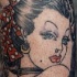 el tatuaje pin up con una chica de labios rojos y un moño en su pelo