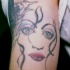 el tatuaje de rostro femenino hecho en el brazo