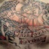 el tatuaje de un barco pirata en el mar con otros detalles del tema hecho en el pecho