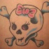 el tatuaje femenino de la calavera con un moño