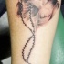el tatuaje de las manos orantes con rosario hecho en tinta negra