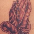 el tatuaje de las manos orantes con rosario