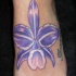 Orchidea viola tatuaggio sul piede