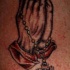 el tatuaje de las manos orantes con rosario hecho en color