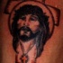 el tatuaje de jesucrista sobre la cruz hecho en color