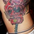 Teschio rosso stilizzato tatuato sul fianco
