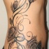 Grandes rosas en el costo tatuaje en tinta oscura