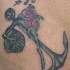 el tatuaje conmemorativo de una ancla con rosa hecho en color