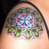 Tatuaggio colorato  sul deltoide il disegno in forma rotonda
