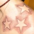 Tatuaggio non colorato sulla clavicola tre stelle bianche