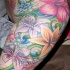 Tatuaggio grande colorato sul deltoide e sul braccio i fiori variabili