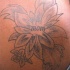 Tatuaje en hombro flor simple con una inscripción 