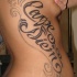 Tatuaggio sul fianco gli ornamenti & la scritta 