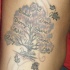 Le tatouage de flanc avec  l'arbre de famille avec beaucoup de feuilles et des prénoms