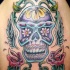 Tatuaje de calavera con tracería floral y las alas