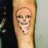 Calavera en máscara blanca tatuaje en el brazo