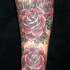Perfectas rosas en tinta roja tatuaje en la manga