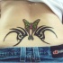 tribale trafori con farfalla tatuaggio sulla parte bassa della schiena