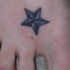 el tatuaje pequeño de una estrella nautica hecho en el pie