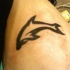 Tatuaje en tinta negra silueta del delfín