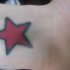 Tatuaje en tinta roja estralla en la pierna