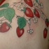Precioso tatuaje la vid con las fresas en colores brillantes