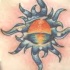 Símbolo del sol con la puesta del sol en el mar tatuaje en color