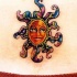 Pequeño símbolo del sol aspecto humano tatuaje en color