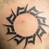 Tatuaje en tinta negra sol estilo tribal