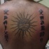 Sol con inscripción tatuaje en la espalda